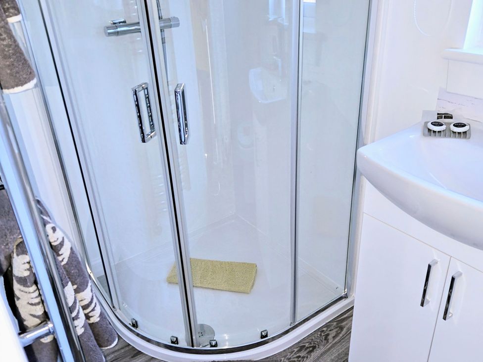 A bathroom with a glass shower and sink at Taigh Nam Moireach in Inverness