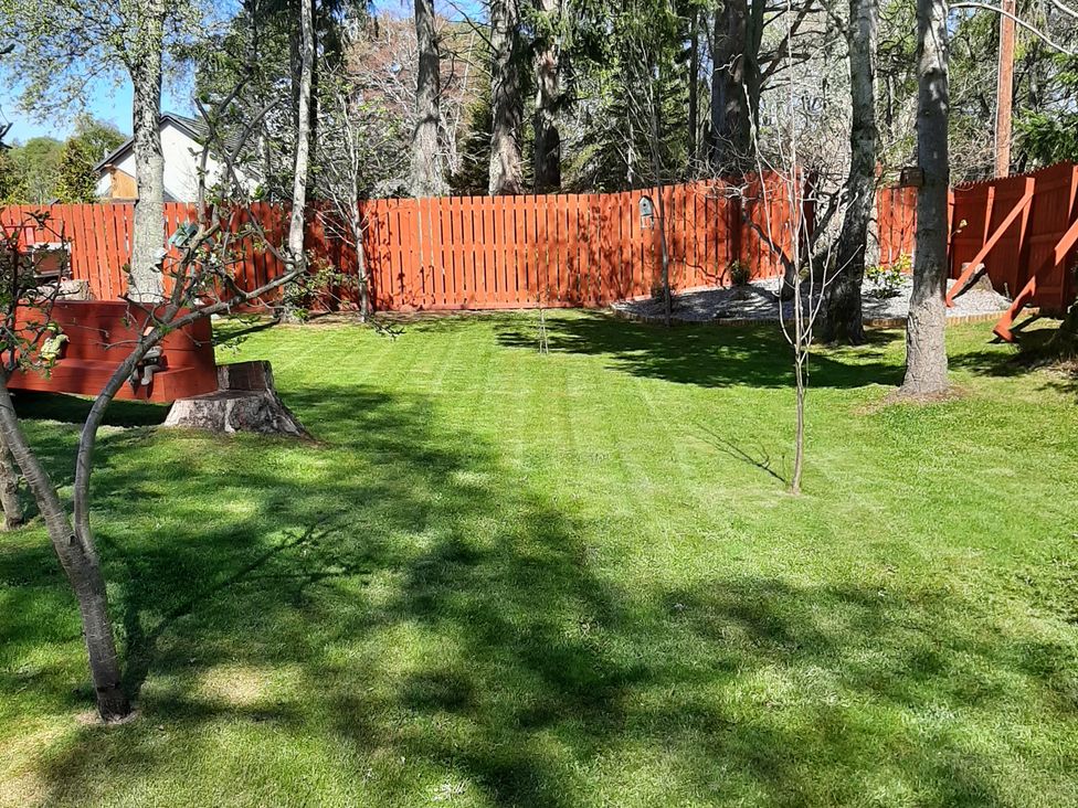 A garden with grass and trees at Taigh Nam Moireach in Inverness
