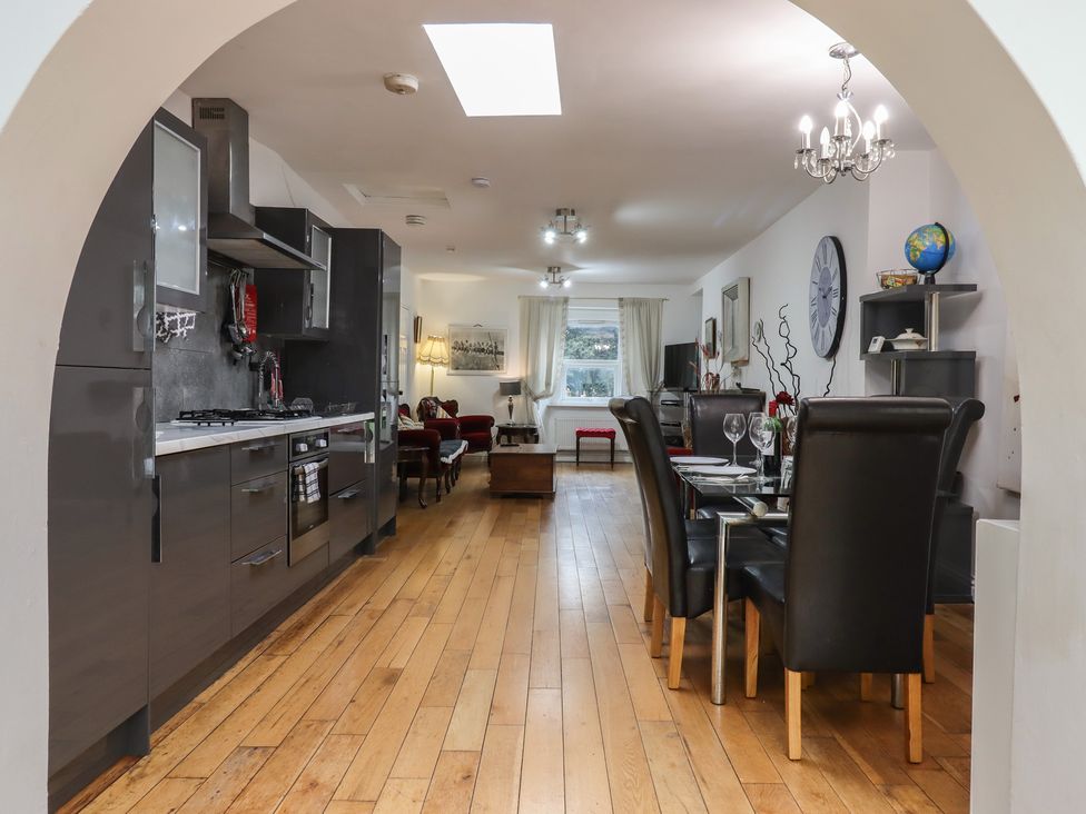 A kitchen with a dining area featuring a table and chairs at Teign Place in Teignmouth