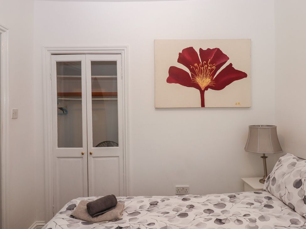 A bedroom with a bed and a wardrobe at Teign Place in Teignmouth