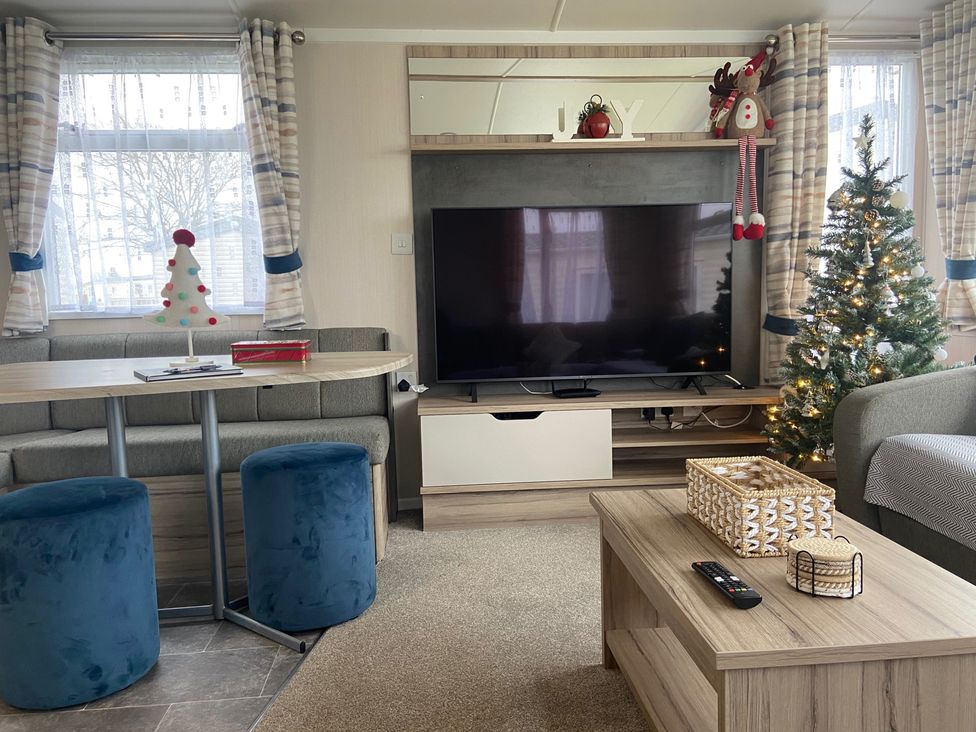 A living room with a television and Christmas tree at Elms 32 in Porthcawl
