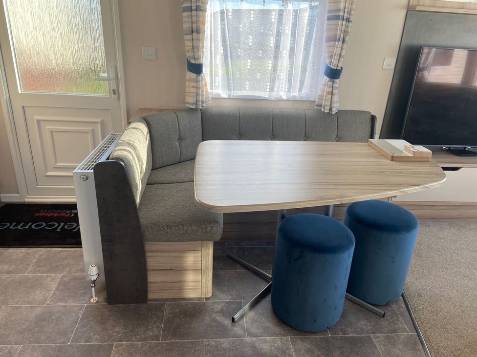 A dining area with a table and seating at Elms 32 in Porthcawl