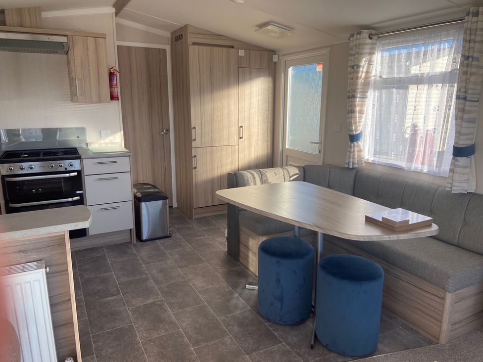 A kitchen with a table and stools at Elms 32 in Porthcawl