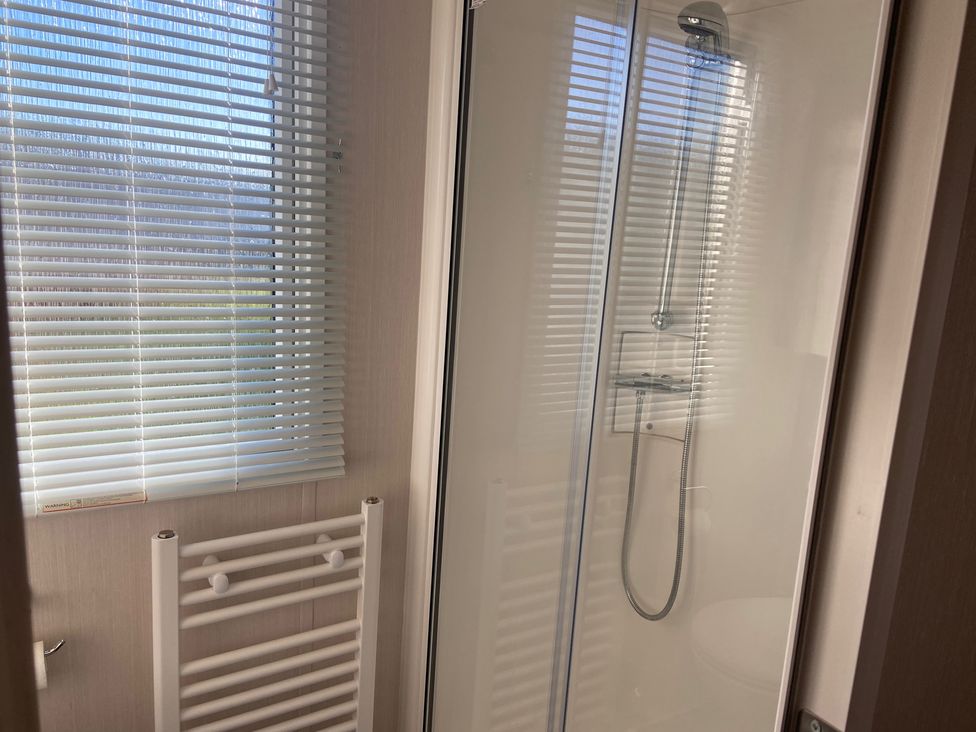 A bathroom with a shower and towel rail at Elms 32 in Porthcawl
