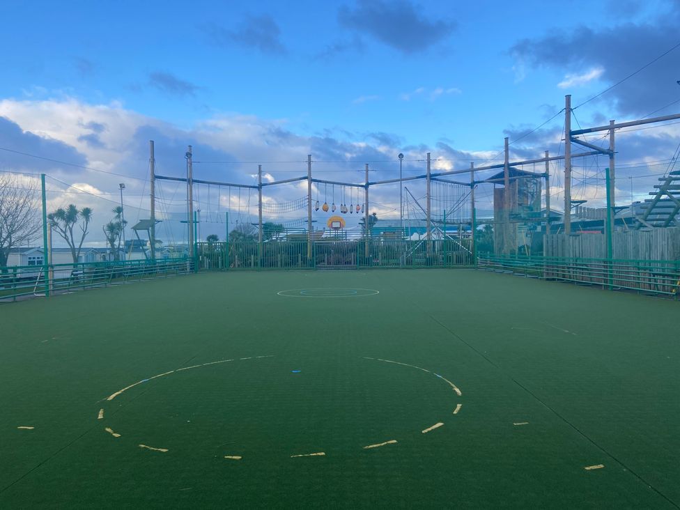 An outdoor sports field with artificial grass and a basketball hoop at Elms 32 Porthcawl