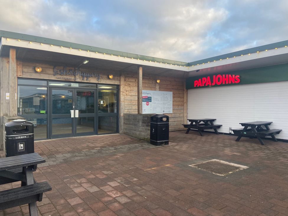 An outdoor area with a restaurant entrance and seating at Elms 32 in Porthcawl
