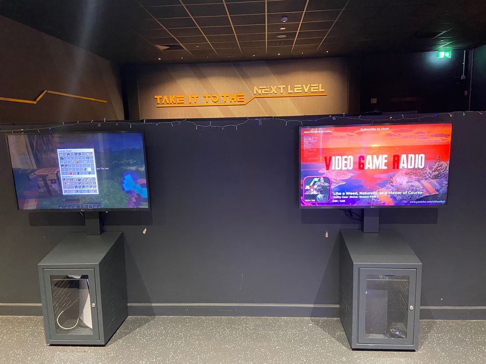 A game room with two televisions displaying game content at Elms 32 in Porthcawl
