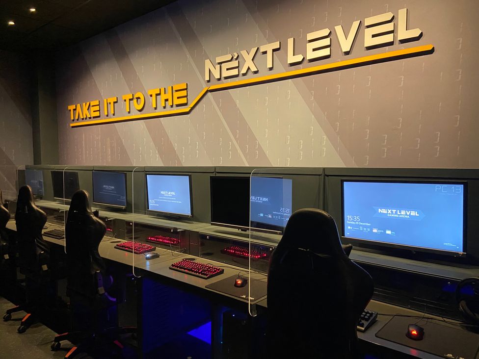 A gaming area with computers and chairs at Elms 32 in Porthcawl