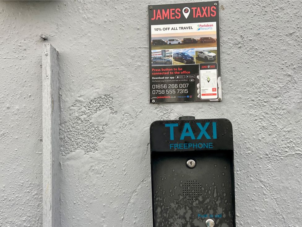 A taxi freephone with an advertisement for James Taxis attached
