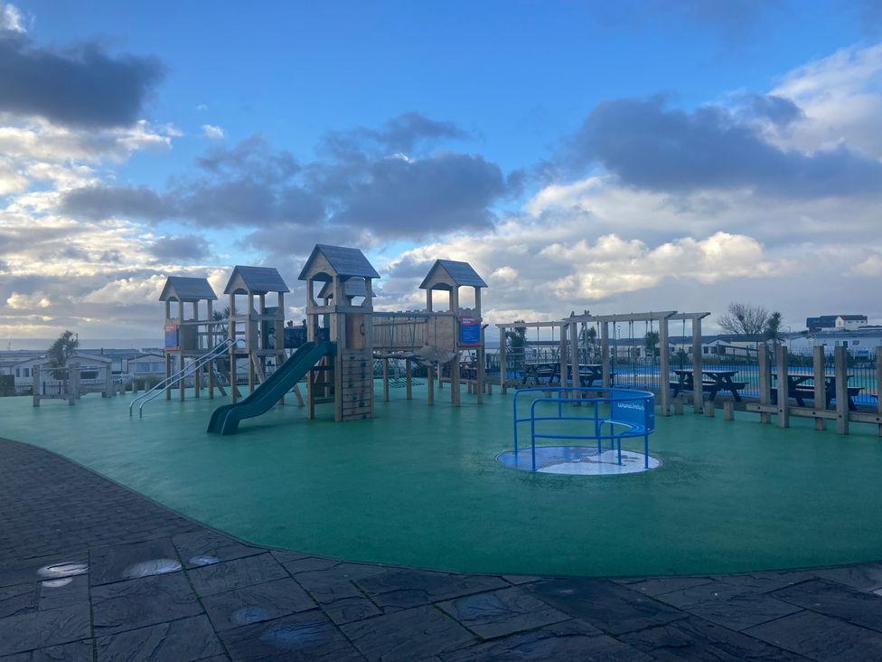 A playground with a slide and climbing frame at Elms 32 in Porthcawl