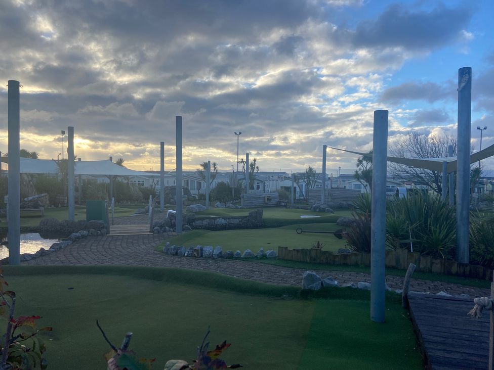 A mini golf course with pathways and greenery at Elms 32 in Porthcawl