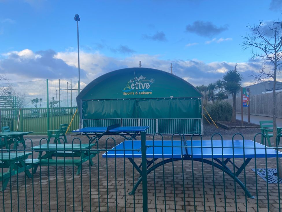 An outdoor sports facility with tables and a service area at Elms 32 in Porthcawl