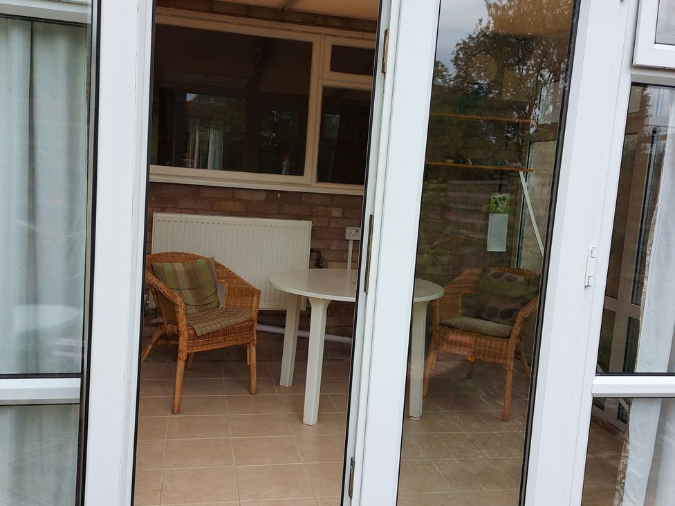 A conservatory with chairs and a table at 60 Pond Bank in Northampton