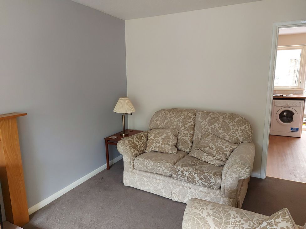 A living room with a sofa and table at 60 Pond Bank in Northampton