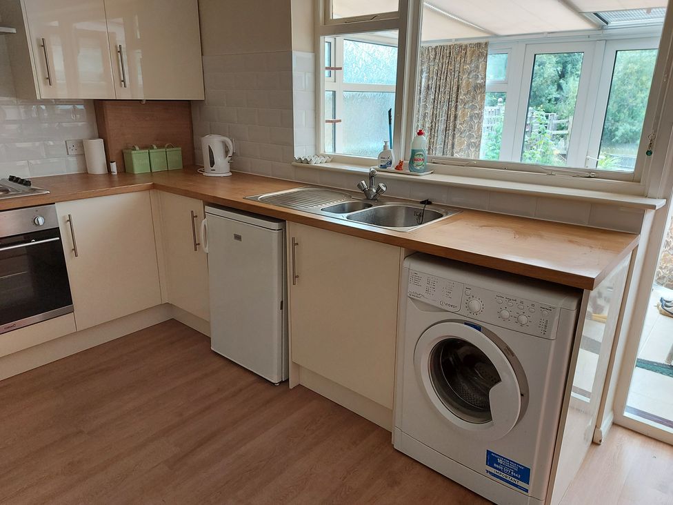 A kitchen with a sink and washing machine at 60 Pond Bank Northampton