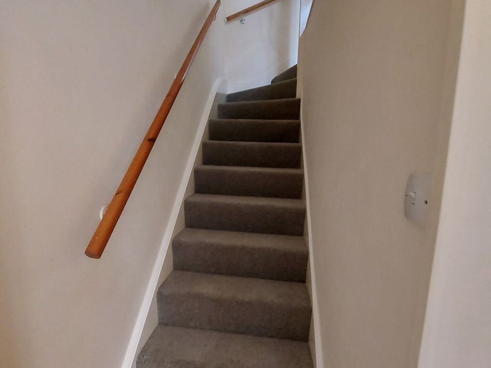 A staircase with a wooden handrail at 60 Pond Bank, Northampton