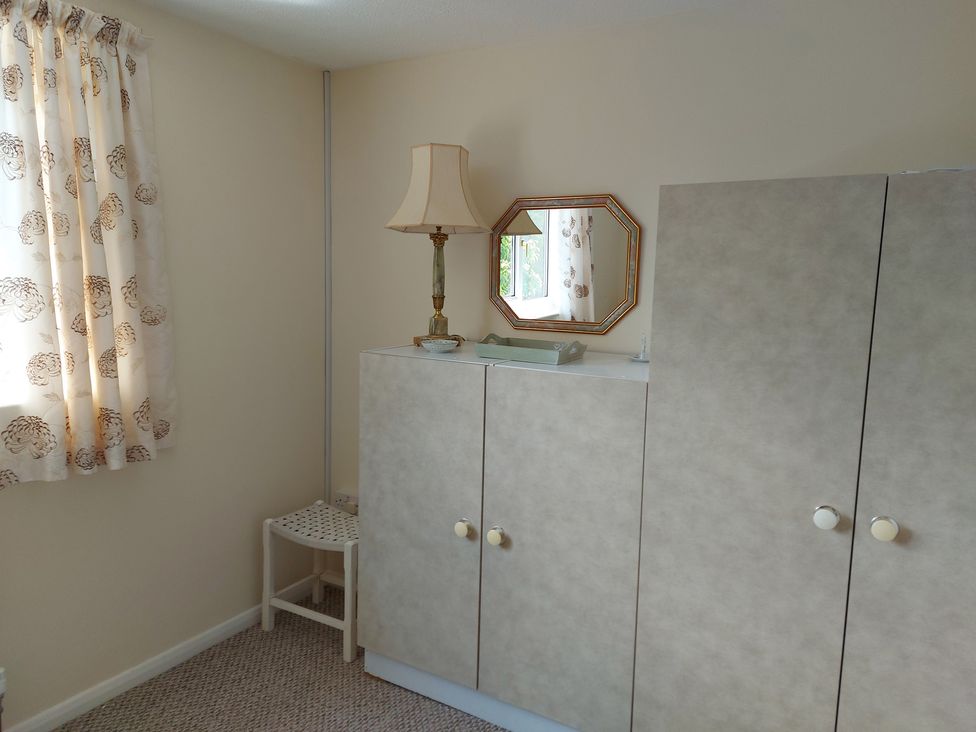 A bedroom with a lamp and mirror at 60 Pond Bank in Northampton