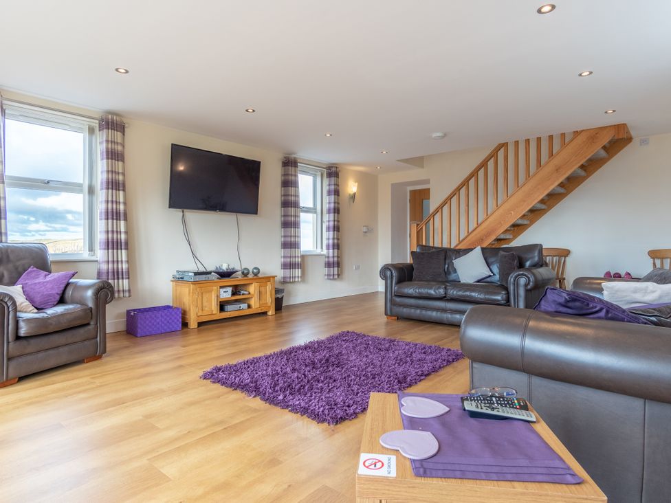 A living room with a television and seating area at Groeslon Uchaf in Caernarfon