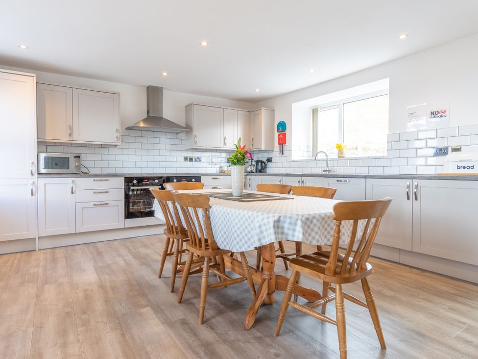 A kitchen with a dining table and chairs at Groeslon Uchaf in Caernarfon
