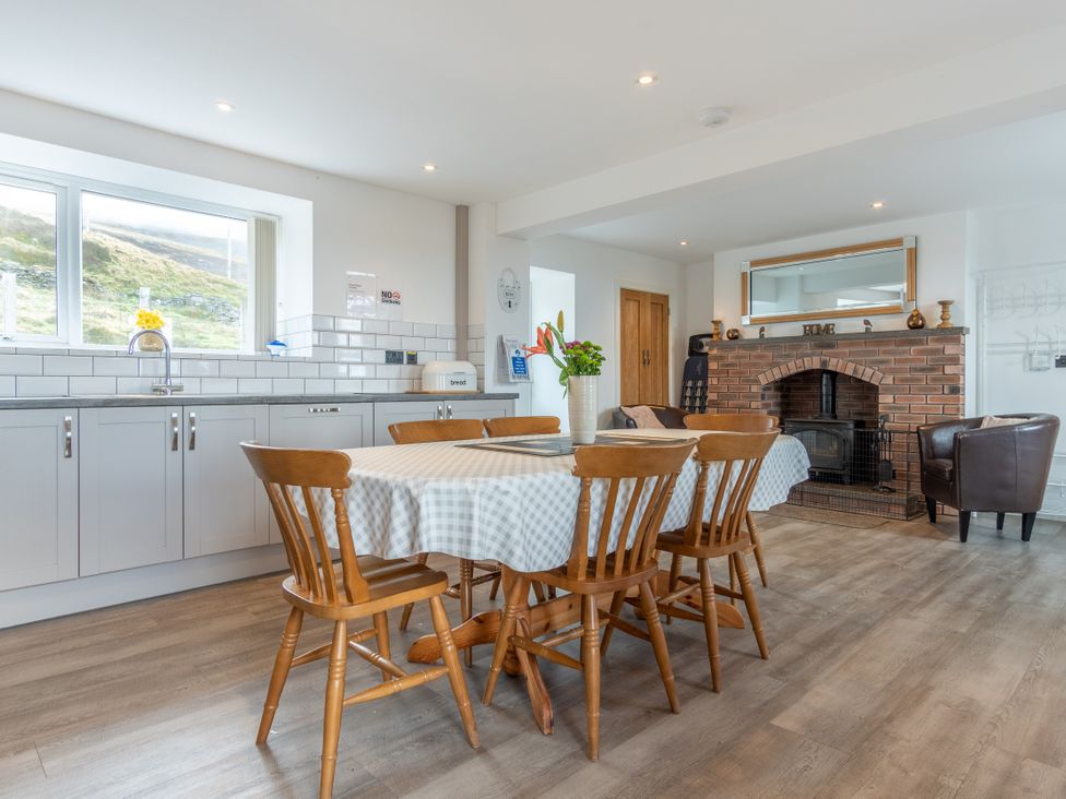A kitchen with a table and chairs at Groeslon Uchaf, Caernarfon
