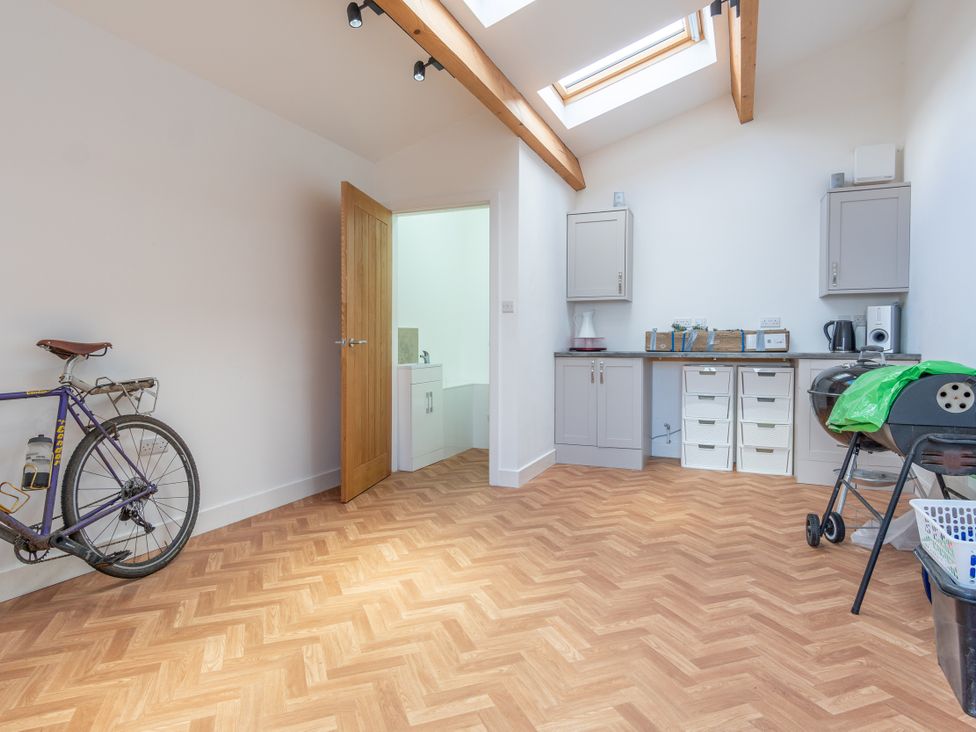 A utility room with a bicycle and kitchen cabinets at Groeslon Uchaf in Caernarfon