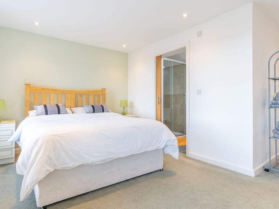 A bedroom with a bed and bathroom entrance at Groeslon Uchaf in Caernarfon