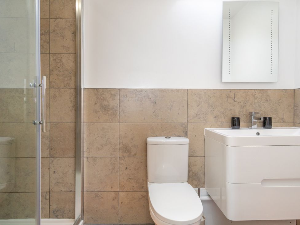 A bathroom with a shower, toilet, and sink at Groeslon Uchaf in Caernarfon