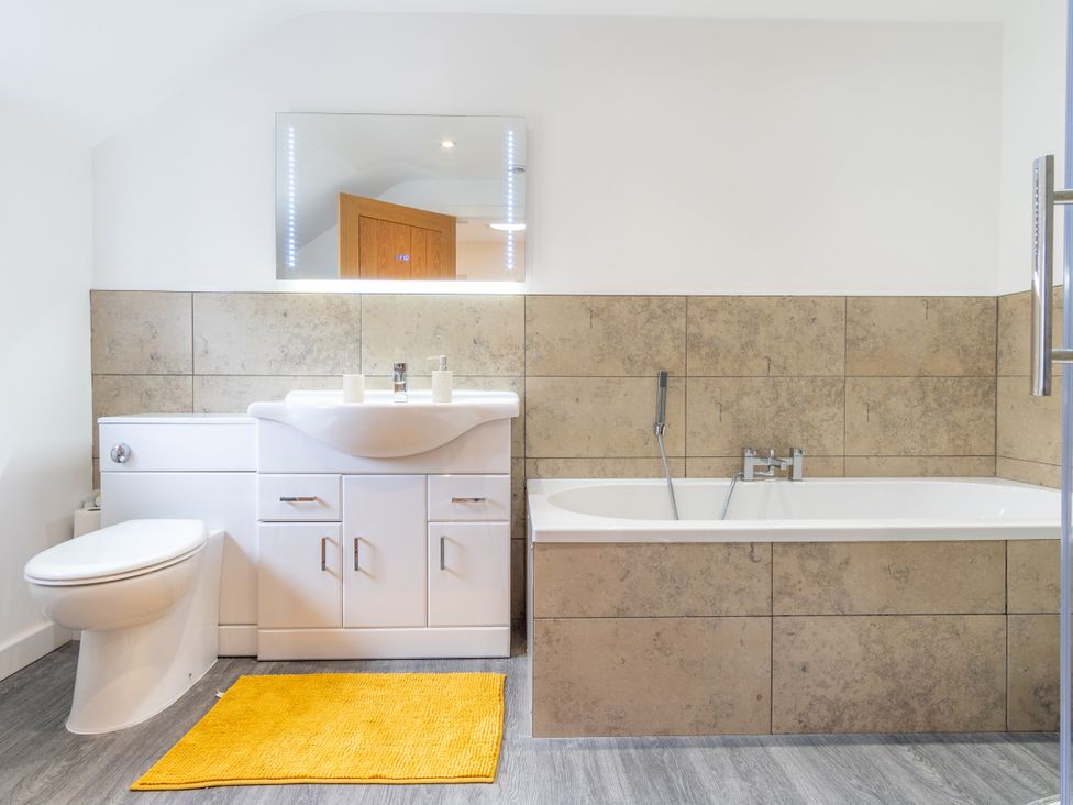 A bathroom with a toilet, sink, and bath tub at Groeslon Uchaf in Caernarfon