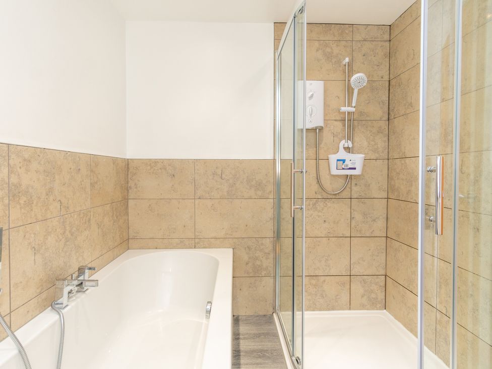 A bathroom with a bathtub and shower at Groeslon Uchaf in Caernarfon