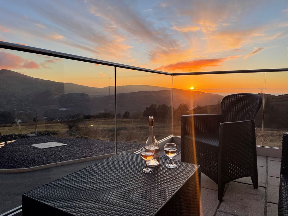An outdoor area with glasses and a bottle at Groeslon Uchaf, Caernarfon