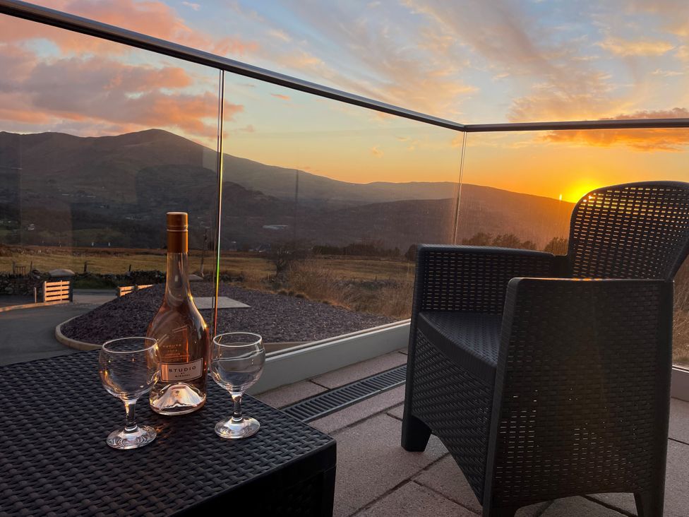 A table with a bottle and glasses at Groeslon Uchaf in Caernarfon