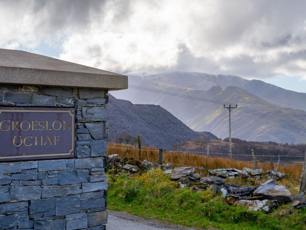 A sign for Groeslon Uchaf with mountains in the background at Groeslon Uchaf in Caernarfon