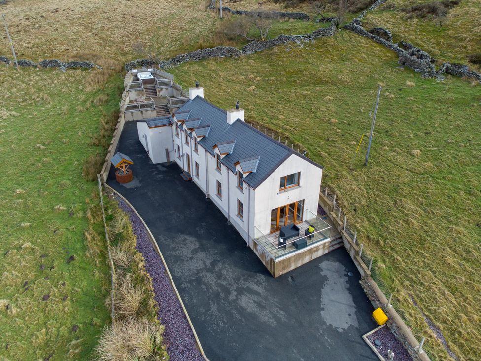 An exterior view of a house with a deck and garden at Groeslon Uchaf in Caernarfon