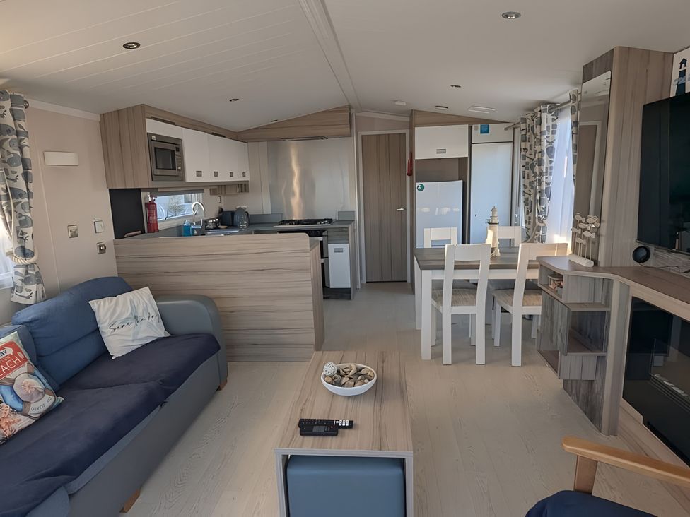 A living room with a kitchen and dining area at Lighthouse Lodge in Mablethorpe