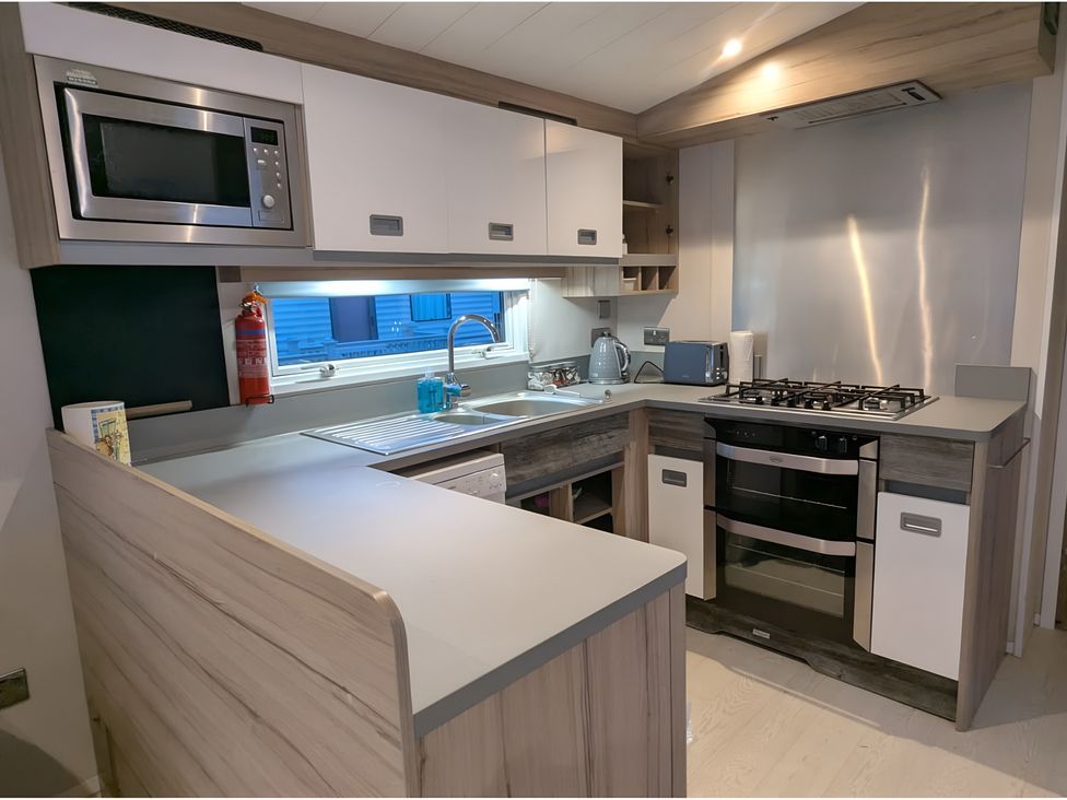A kitchen with appliances and fixtures at Lighthouse Lodge in Mablethorpe