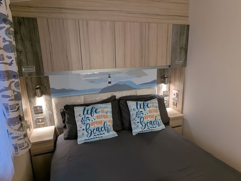 A bedroom with a bed and decorative pillows at Lighthouse Lodge in Mablethorpe