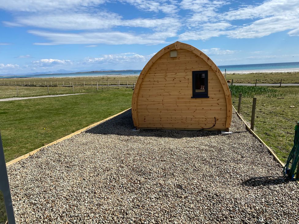 An outdoor view of a wooden pod with a window at Kirkapol Beach Pod - Flow Isle of Tiree
