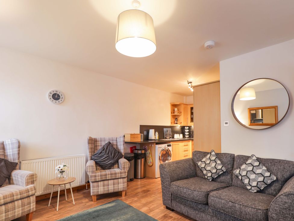 A living room with a sofa and armchairs at 1 Roseneath Terrace, Nairn