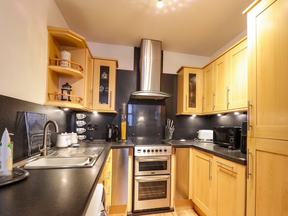 A kitchen with cabinets, sink, stove, and appliances at 1 Roseneath Terrace Nairn