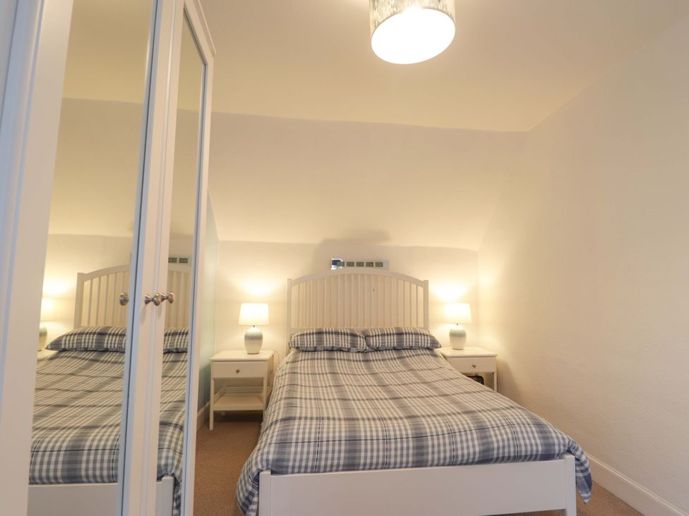 A bedroom with a bed and nightstand at 1 Roseneath Terrace Nairn