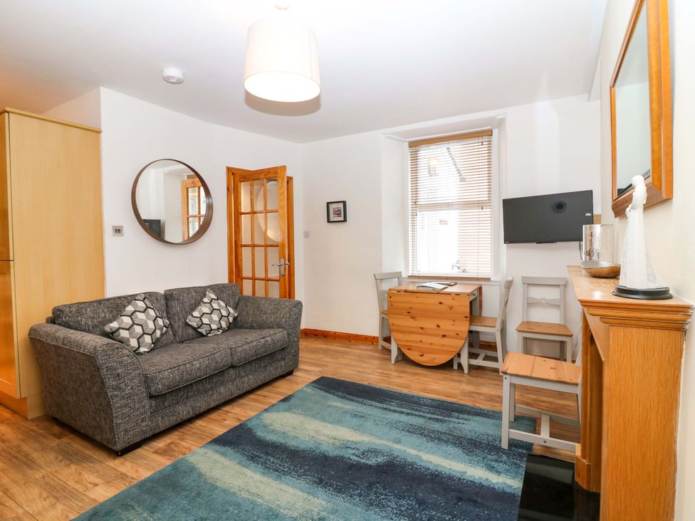 A living room with a sofa and a table at Rose Cottage in Nairn
