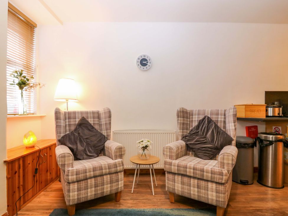 A snug with armchairs and a side table at Rose Cottage in Nairn