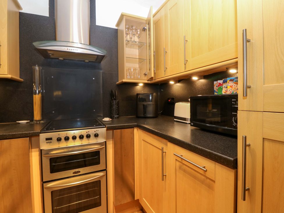 A kitchen with various appliances including oven and microwave at Rose Cottage, Nairn