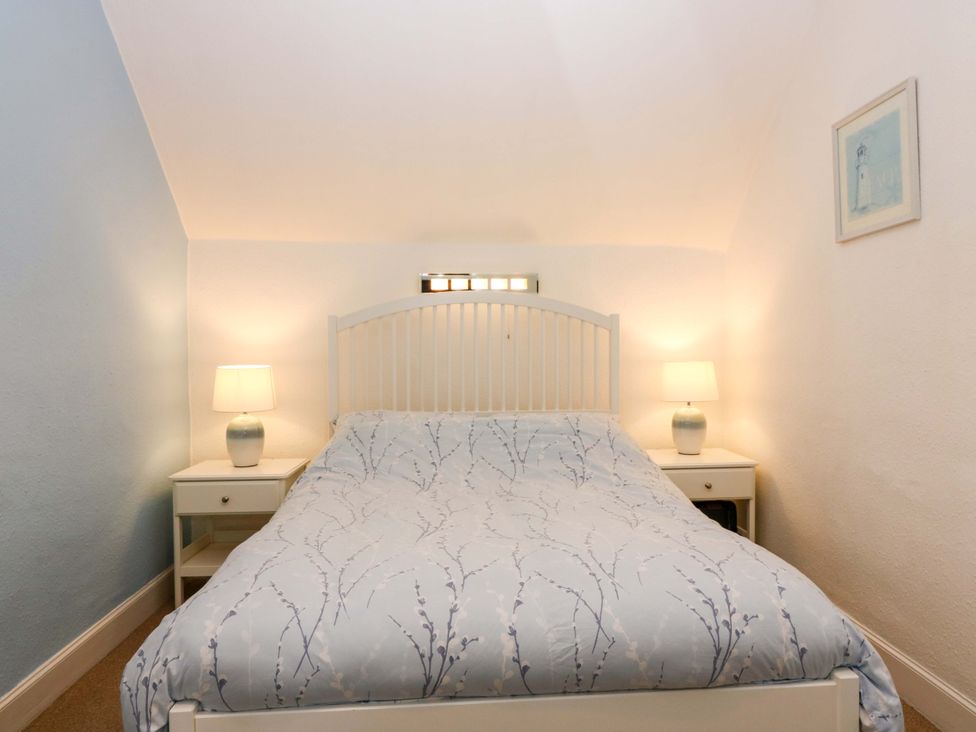 A bedroom with a bed and bedside tables at Rose Cottage Nairn