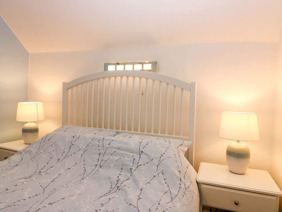 A bedroom with a bed and bedside tables at Rose Cottage Nairn