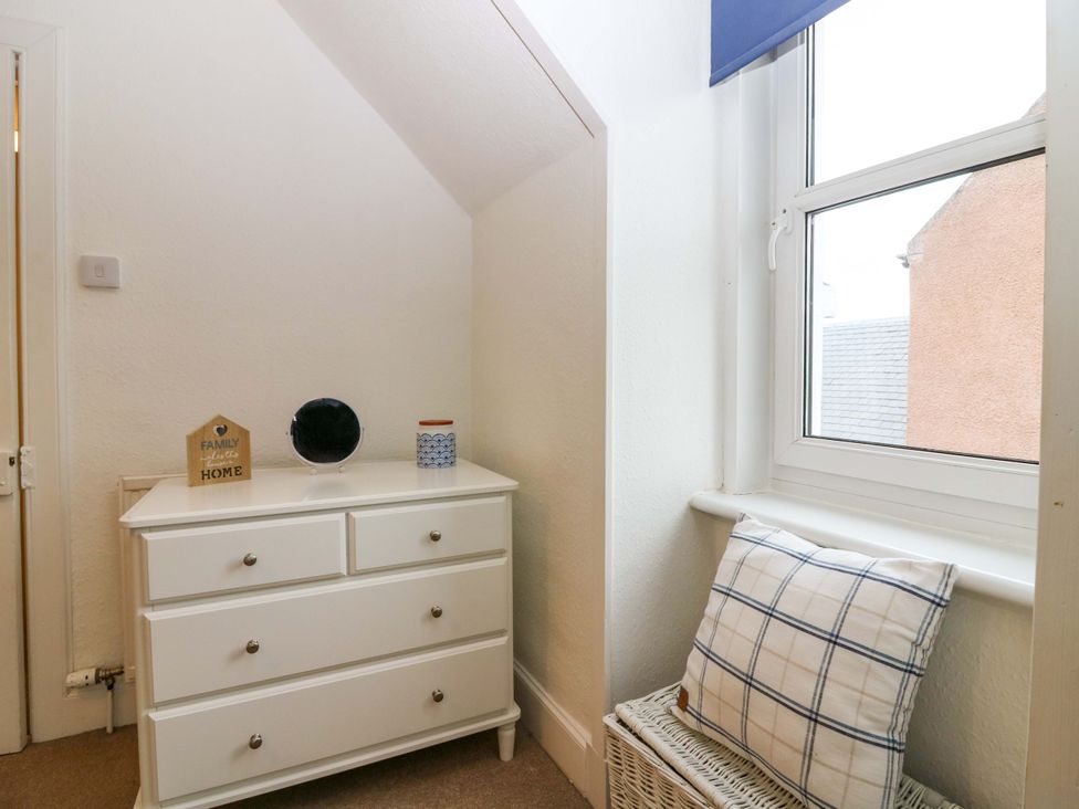A bedroom with a dresser and window at Rose Cottage Nairn