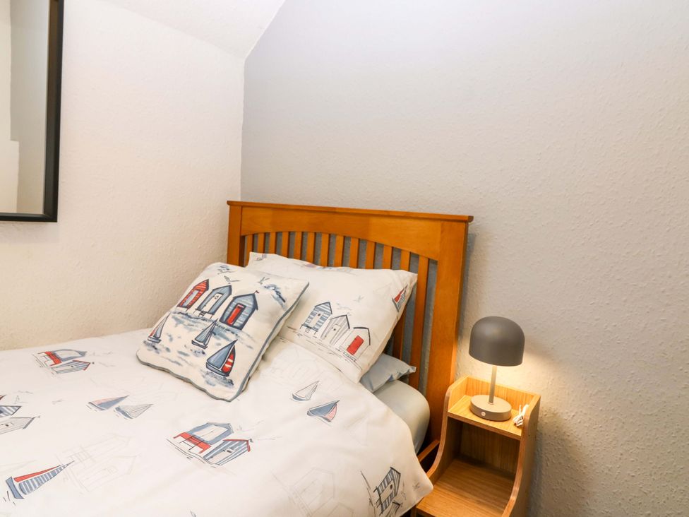 A bedroom with a bed and bedside table at Rose Cottage in Nairn