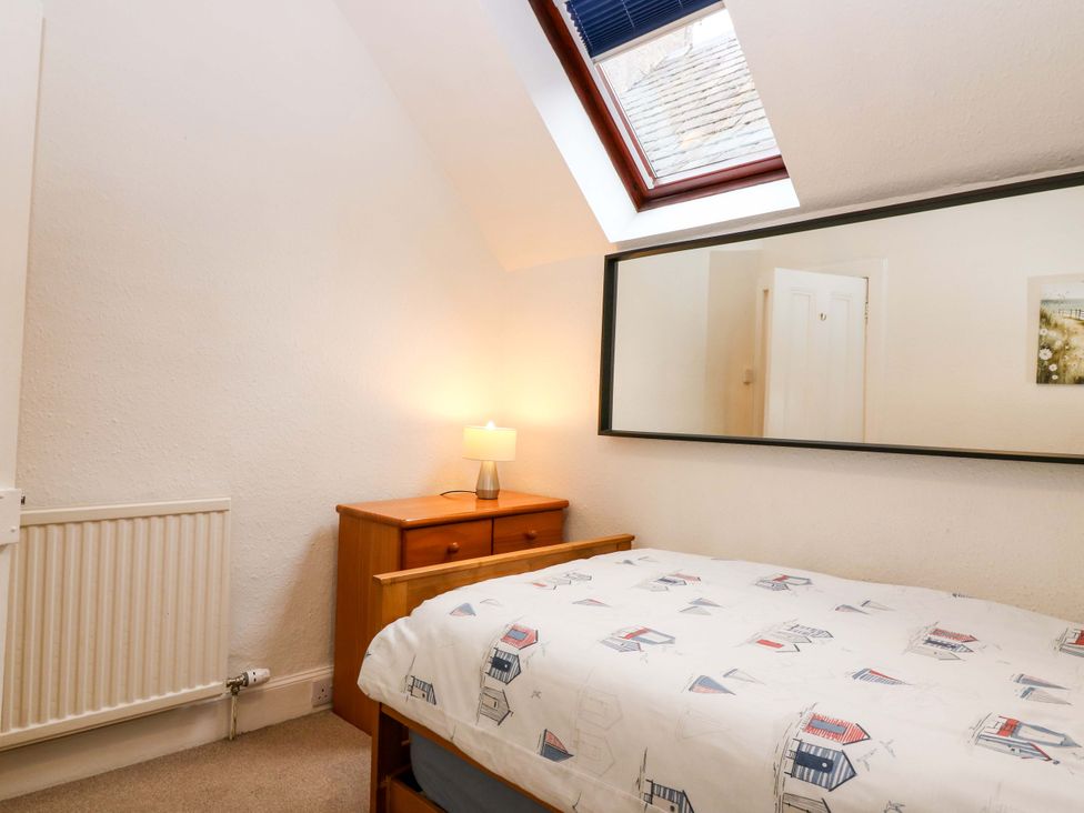 A bedroom with a bed and a lamp at Rose Cottage in Nairn