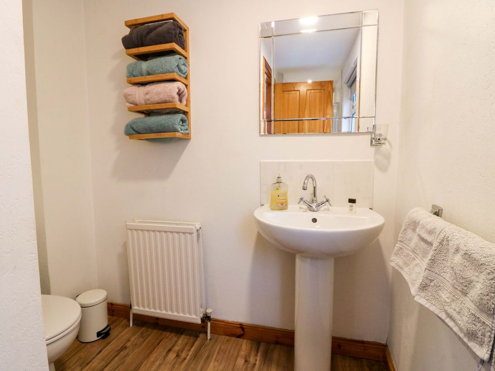 A bathroom with a sink, toilet, and towel rack at Rose Cottage in Nairn