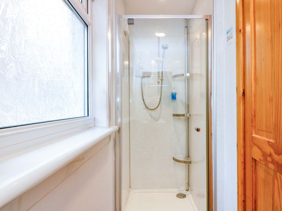 A shower enclosure with glass door and controls at Rose Cottage Nairn